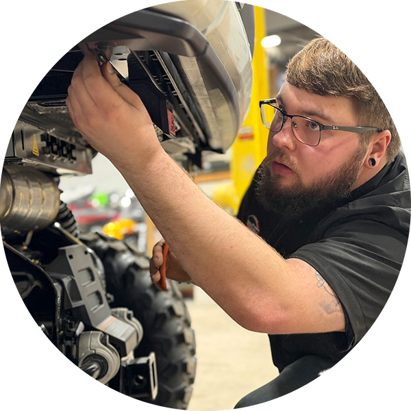 a UTV technician performing routine maintenance on a UTV