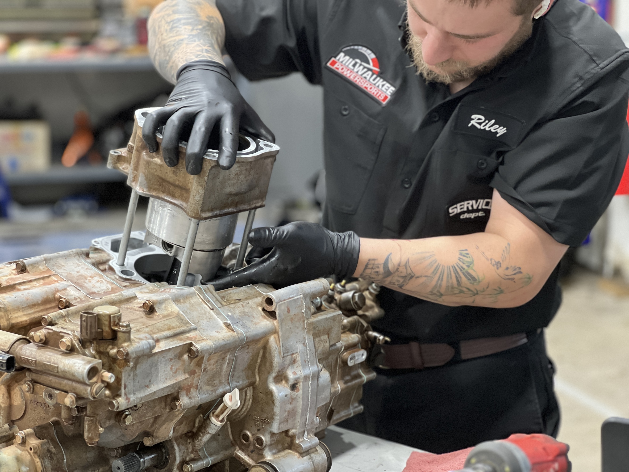 A Milwaukee Powersports technician repairing an engine.