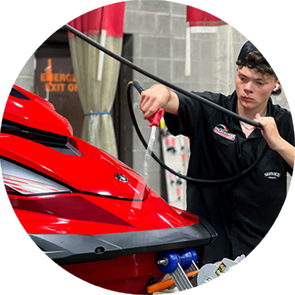 a watercraft technician washing a personal watercraft